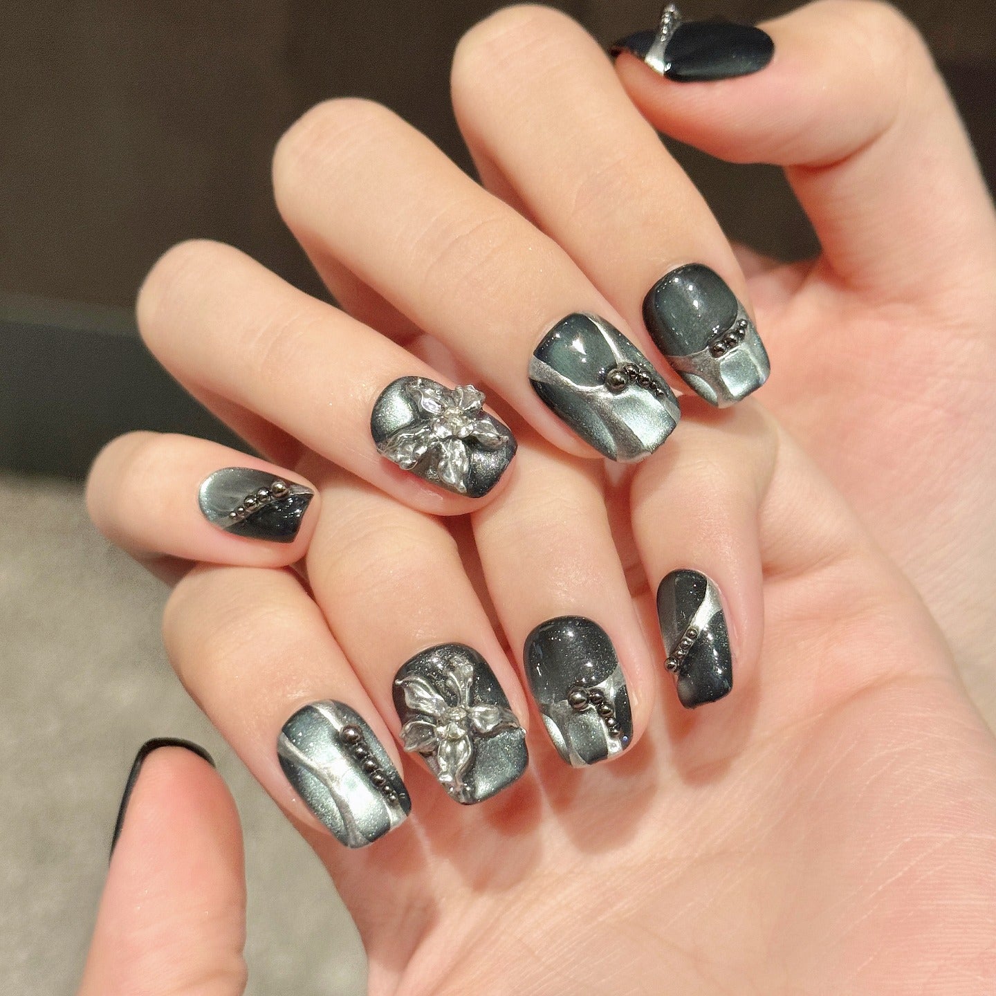 Black cat-eye style nail polish and wearable nail pads